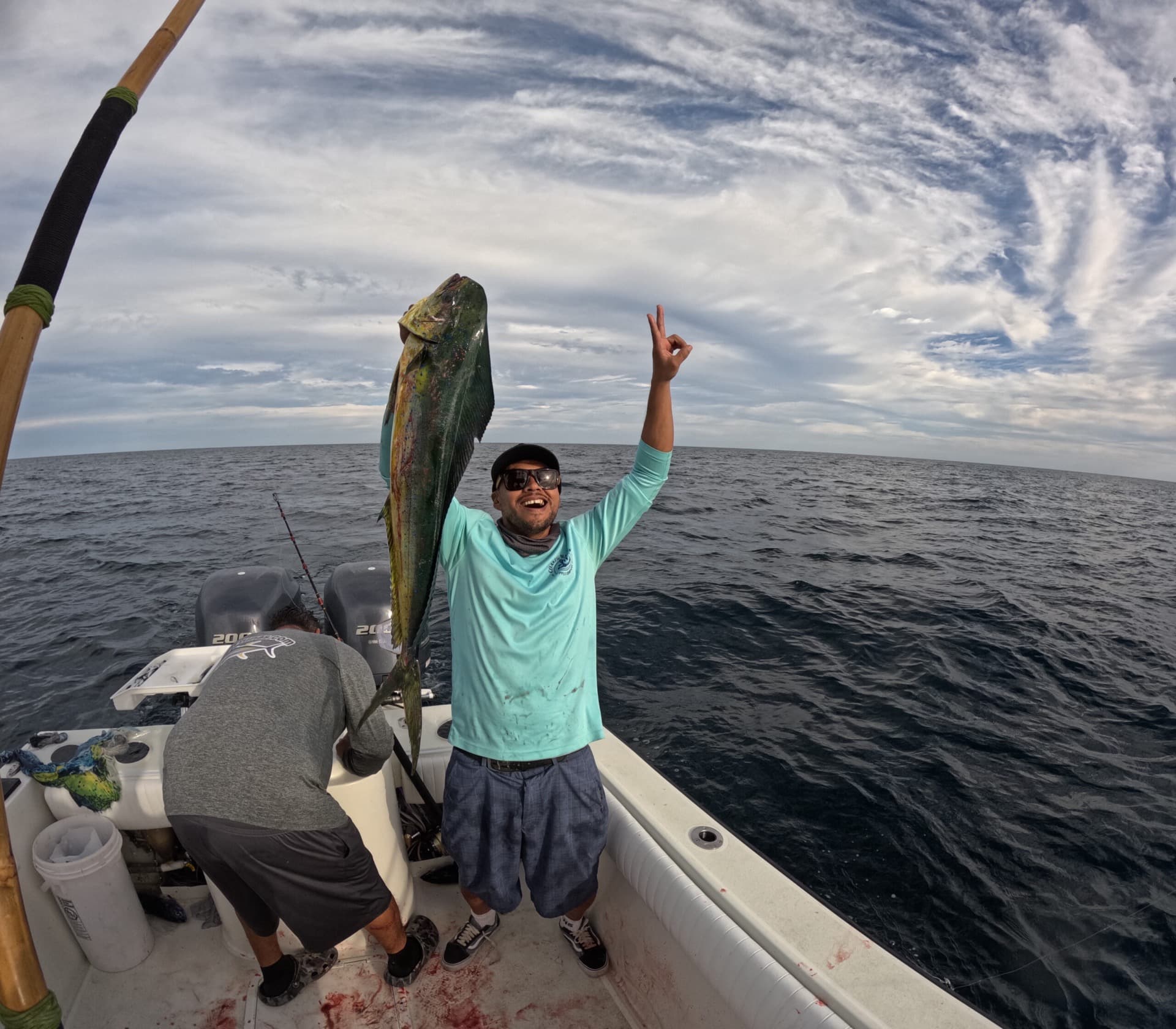 Happy angler holding a mahi-mahi aboard the Kailani